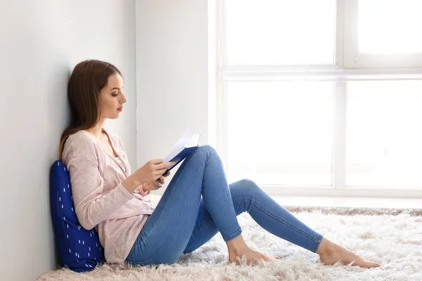 Belle jeune femme lecture livre à la maison — Photo