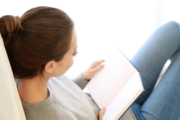 Mooie jonge vrouw die thuis boek leest — Stockfoto