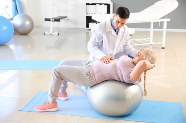 Rehabilitasyon merkezinde olgun hasta ile çalışan fizyoterapist