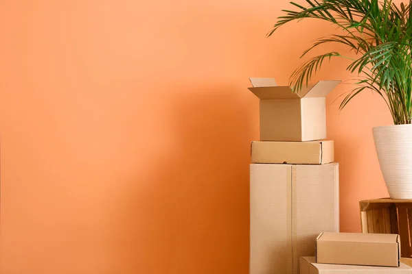 Κουτιά από χαρτόνι με υπάρχοντα παρασκευασμένα για τη μετακίνηση σε νέο σπίτι στο χρώμα φόντο — Φωτογραφία Αρχείου