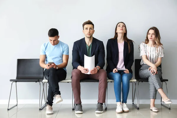 Jóvenes esperando entrevista de trabajo en interiores —  Fotos de Stock