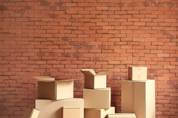 Boîtes en carton près du mur de briques — Photo