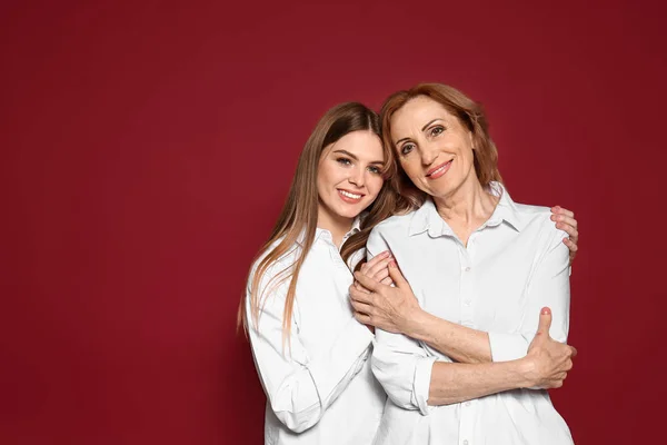 Portrait of happy mother with her daughter on color background — Stock Photo, Image