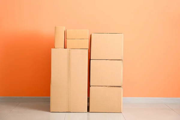 Cardboard boxes near color wall — Stock Photo, Image