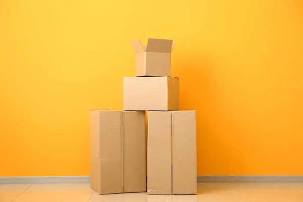 Cardboard boxes near color wall — Stock Photo, Image