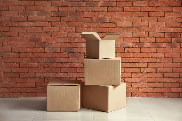 Картонные коробки возле кирпичной стены — стоковое фото