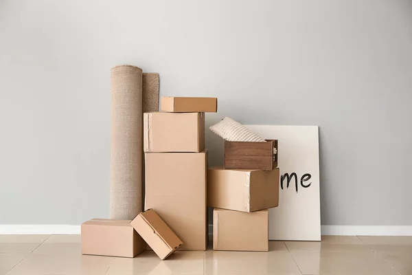 Картонные коробки с вещами, подготовленными для переезда в новый дом возле светлой стены — стоковое фото