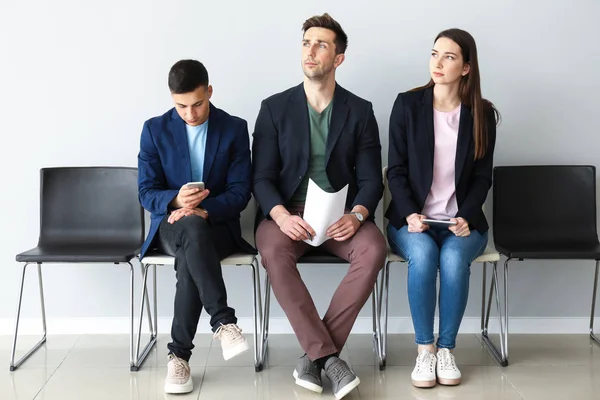 Jóvenes esperando entrevista de trabajo en interiores —  Fotos de Stock