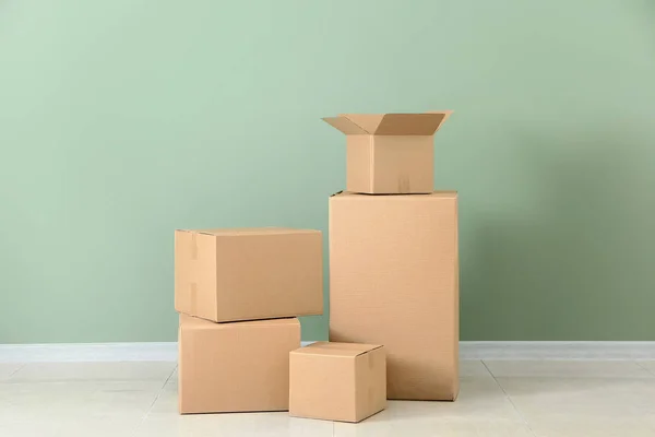 Cardboard boxes near color wall — Stock Photo, Image