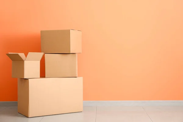 Cardboard boxes near color wall — Stock Photo, Image