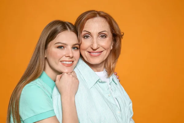 Portrait of happy mother with her daughter on color background — Stock Photo, Image