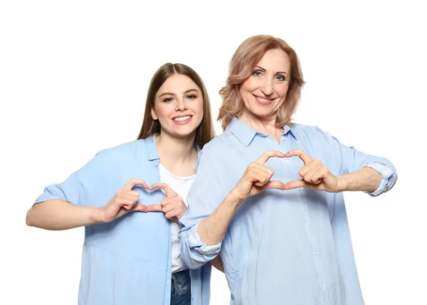 Portrait of happy mother with her daughter holding hands in shape of heart on white background — Stock Photo, Image
