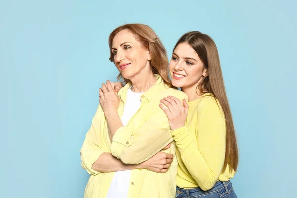 Portrait of happy mother with her daughter on color background — Stock Photo, Image