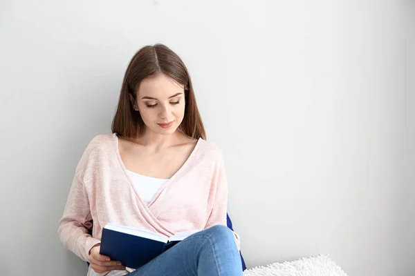 Gyönyörű fiatal nő olvas könyvet otthon — Stock Fotó