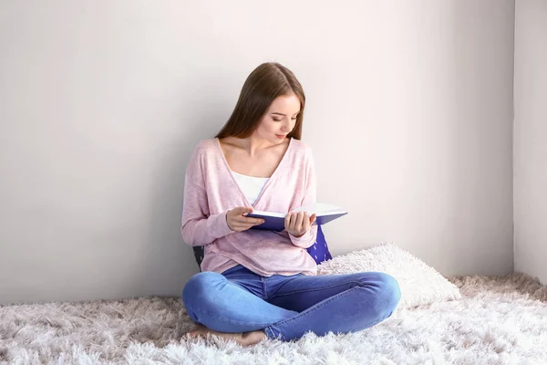 Piękna młoda kobieta czyta książkę w domu — Zdjęcie stockowe