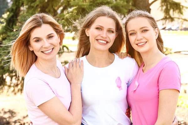 Hermosas mujeres de diferentes edades con cintas rosas al aire libre. Concepto de cáncer de mama — Foto de Stock