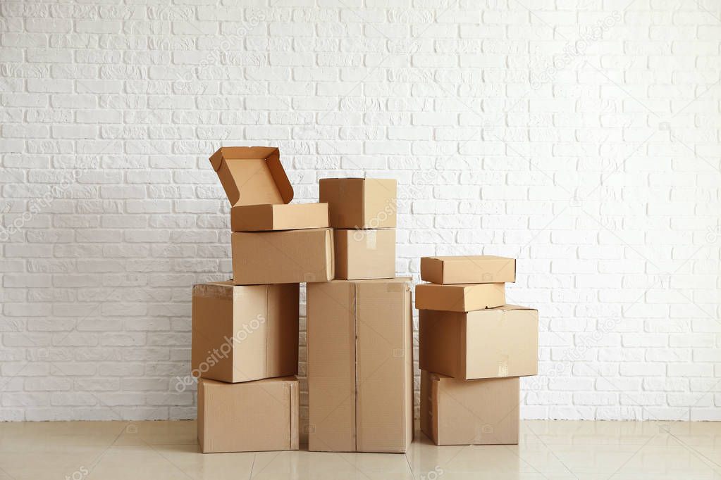Cardboard boxes near white brick wall