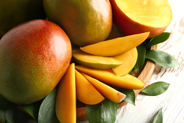 Board with tasty fresh mango on wooden table, closeup — Stock Photo, Image