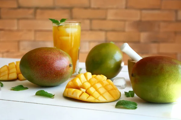 Tasty sweet mango with glass of juice on white table — Stock Photo, Image
