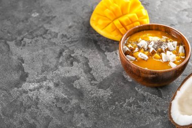 Gri arka planda lezzetli mango smoothie ile Bowl