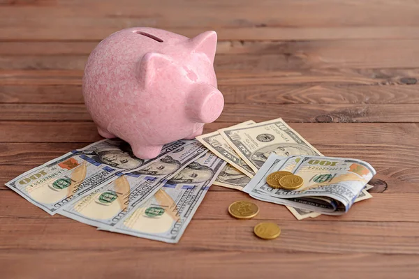 Piggy bank with money on wooden table — Stock Photo, Image