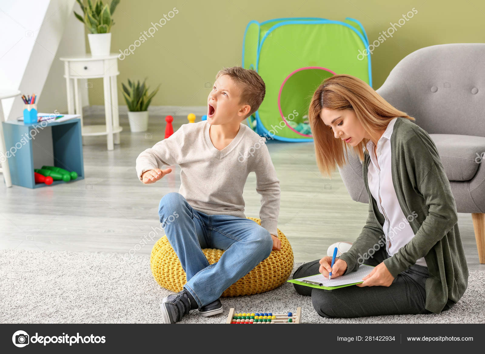 Female psychologist working with boy suffering from autistic disorder