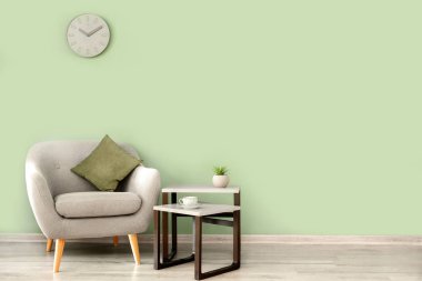 Odadaki renk duvarının yanındaki masa ve koltuk.