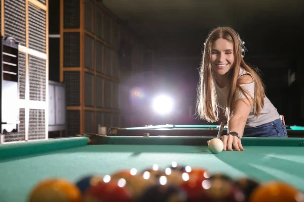Młoda kobieta gra w bilard w klubie — Zdjęcie stockowe