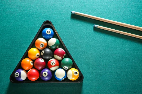 Billiard balls in triangle rack with cues on table — Stock Photo, Image