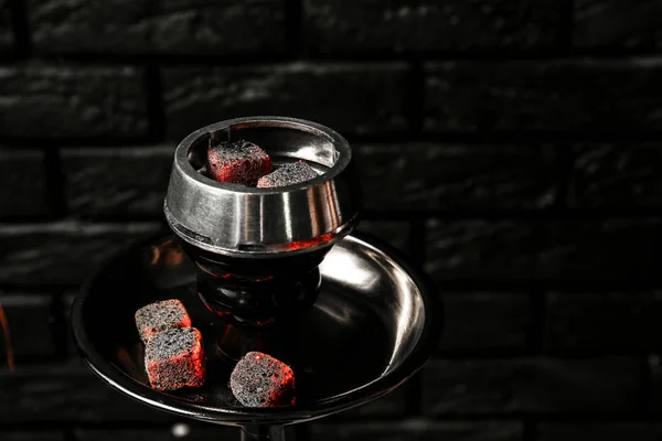 Burning coal for hookah on black brick background — Stock Photo, Image