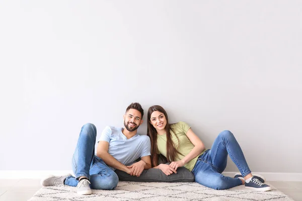 Pareja joven cerca de pared de luz —  Fotos de Stock