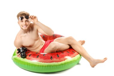 Beyaz arka planda şişme halka ve fotoğraf kamerası ile genç turist