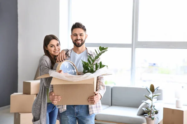 Young couple with belongings in their new house — Stock Photo, Image