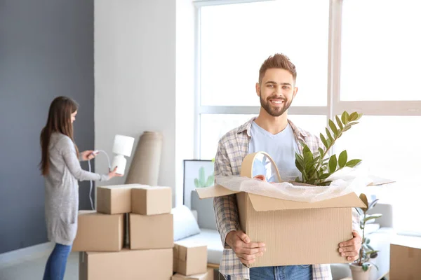 Young man with belongings in his new house — Stock Photo, Image