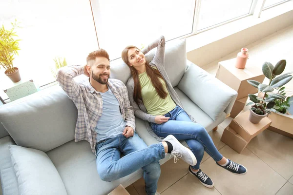 Pareja joven sentada en su nueva casa — Foto de Stock