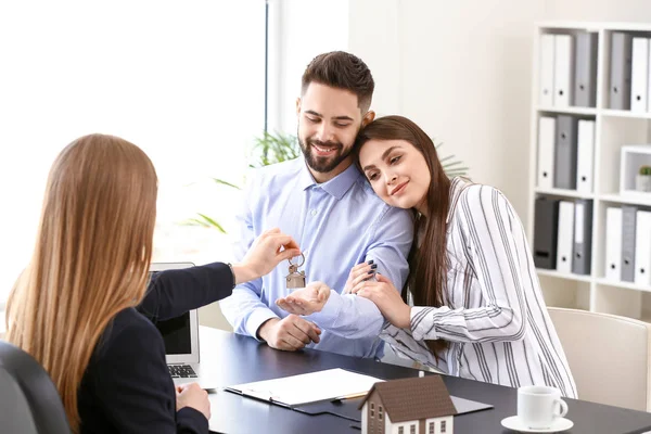 Jovem casal no escritório do agente imobiliário — Fotografia de Stock