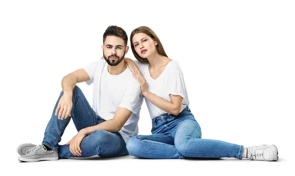 Elegante pareja joven en jeans sobre fondo blanco — Foto de Stock