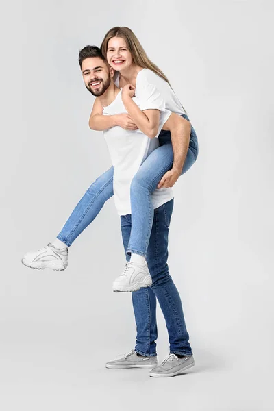 Elegante jovem casal em jeans no fundo branco — Fotografia de Stock