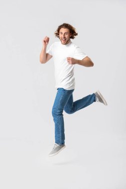 Beyaz arka planda kot pantolon atlama genç adam