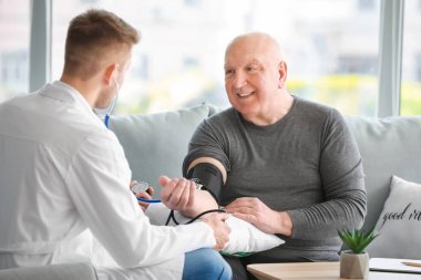 Doktor hemşirelik evde kıdemli adam inceleniyor