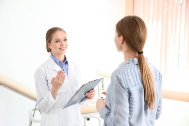 Klinikte bir hastayla çalışan kadın jinekolog.