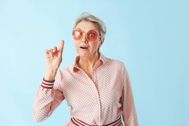 Renk arkaplanı üzerinde işaret parmağı olan olgun bir kadın