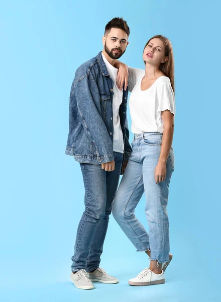 Stylish young couple in jeans clothes on color background — Stock Photo, Image