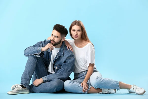 Стильна молода пара в джинсовому одязі на кольоровому фоні — стокове фото
