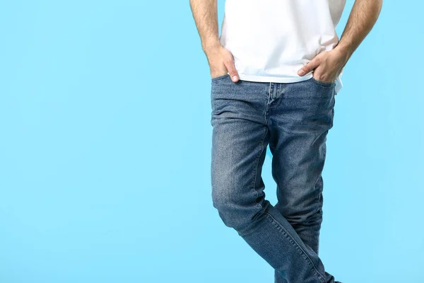 Stylish young man in jeans on color background — Stock Photo, Image