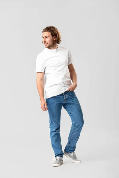 Stilvoller junger Mann in Jeans auf weißem Hintergrund — Stockfoto