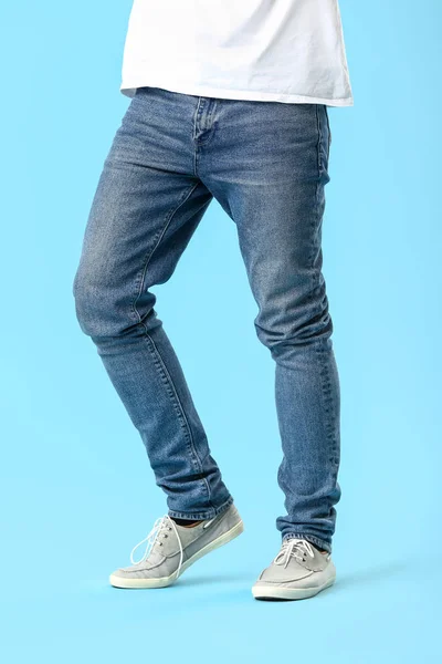 Stylish young man in jeans on color background — Stock Photo, Image