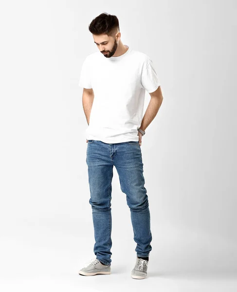 Snygg ung man i jeans på vit bakgrund — Stockfoto