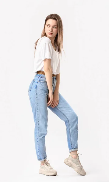 Стильна молода жінка в джинсах на білому тлі — стокове фото