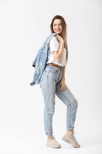 Jeune femme élégante en jeans sur fond blanc — Photo